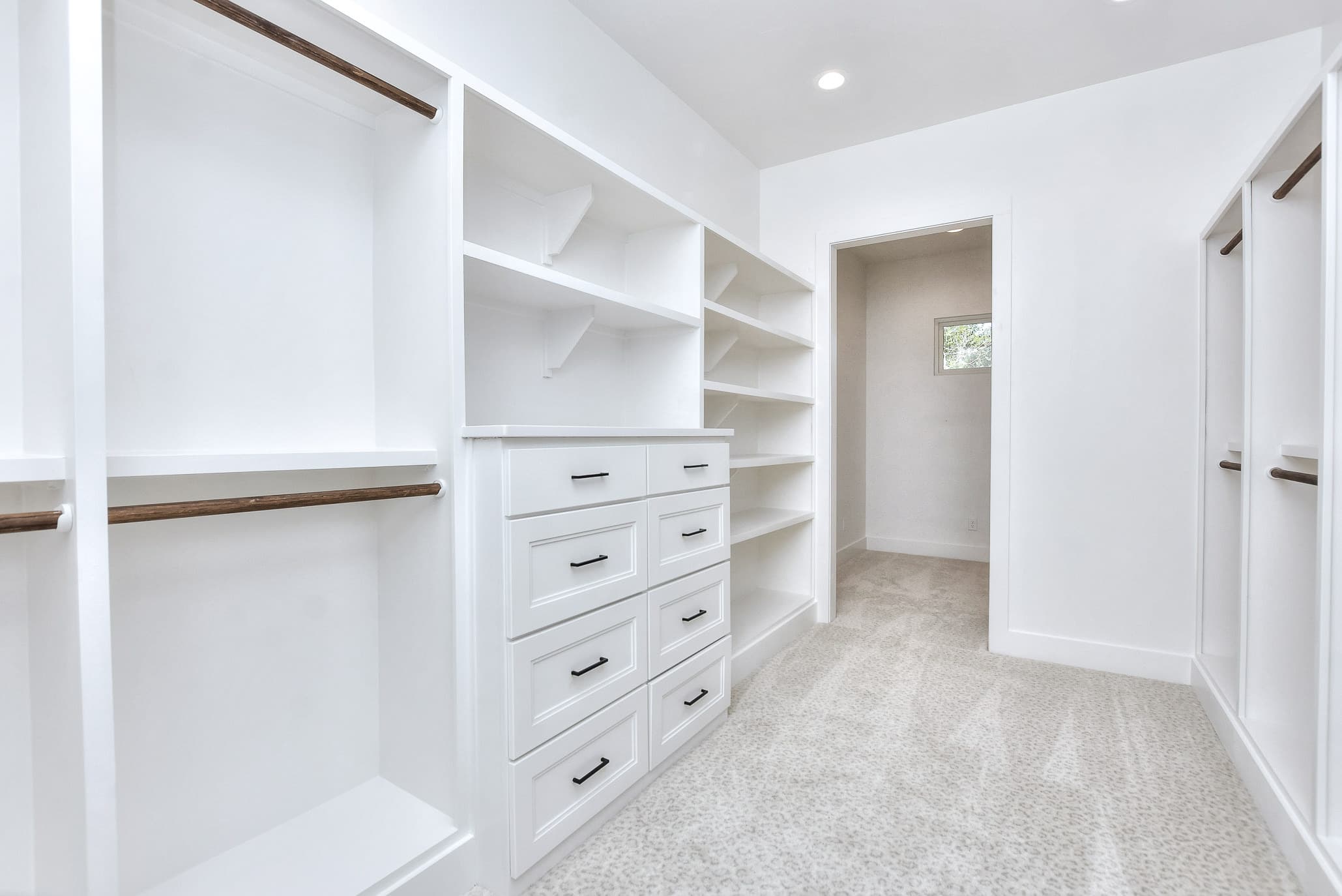 Walk-in closet with a built-in dresser, shelving and hanging rods