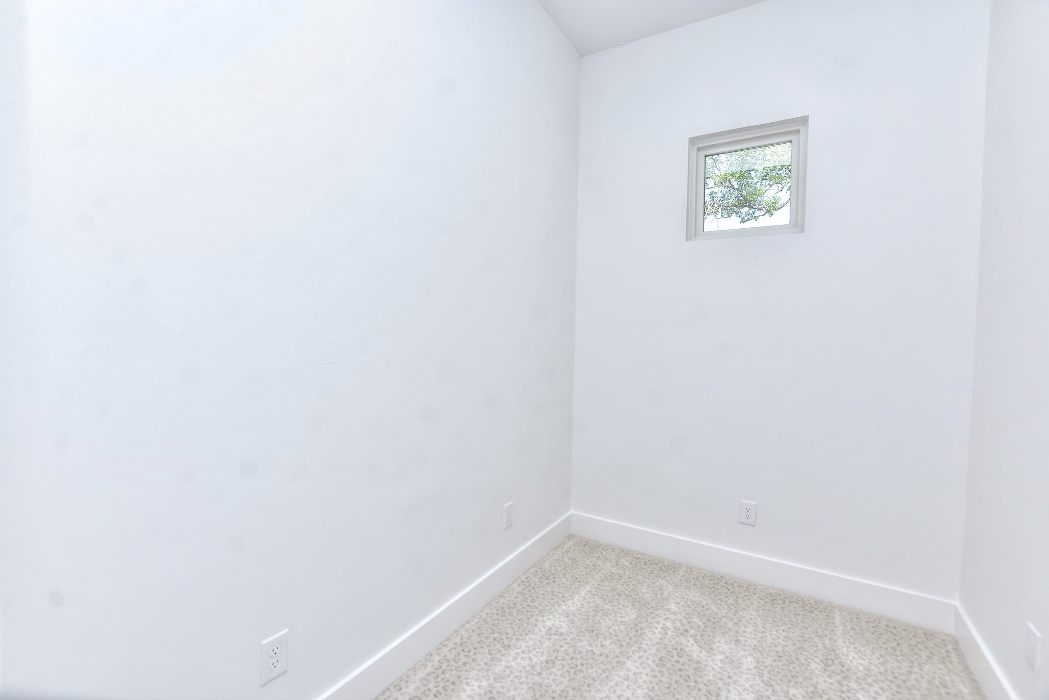 Small finished room with white walls, carpet and a single window