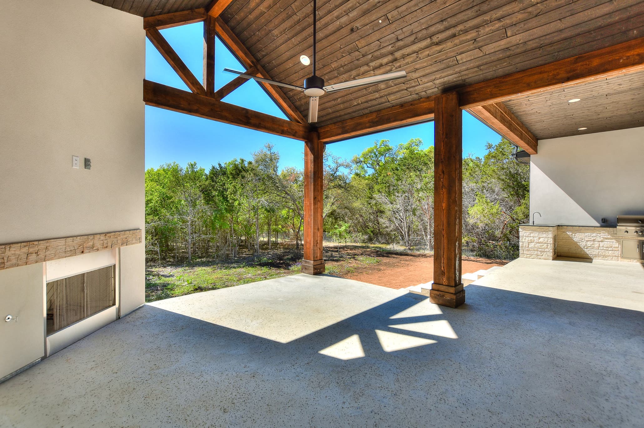 Outdoor living area with a vaulted wood ceiling, fireplace and a view of the oak woods