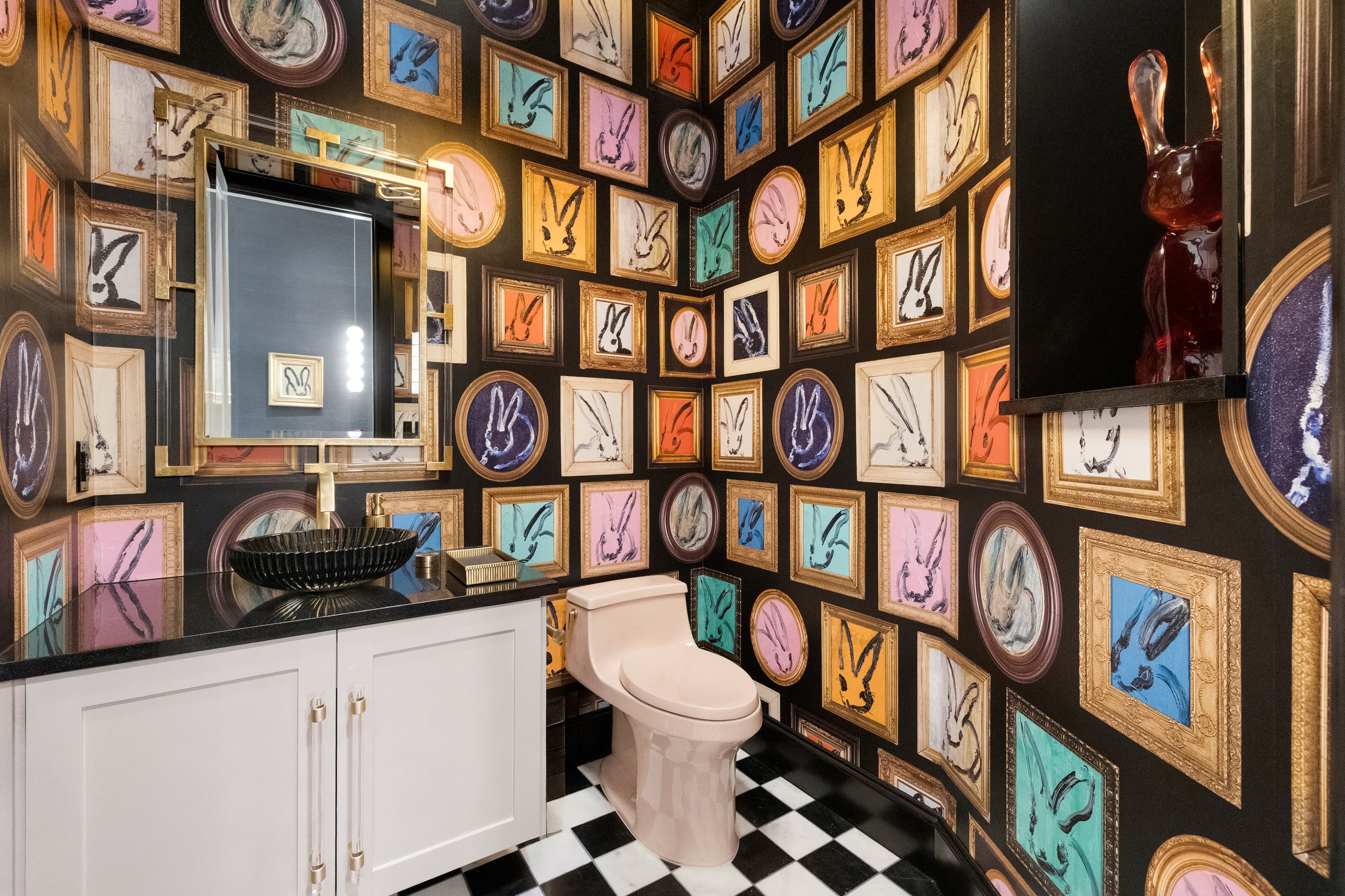 Powder room wallpapered floor to ceiling with framed rabbit art, black sink and checkerboard tile floor