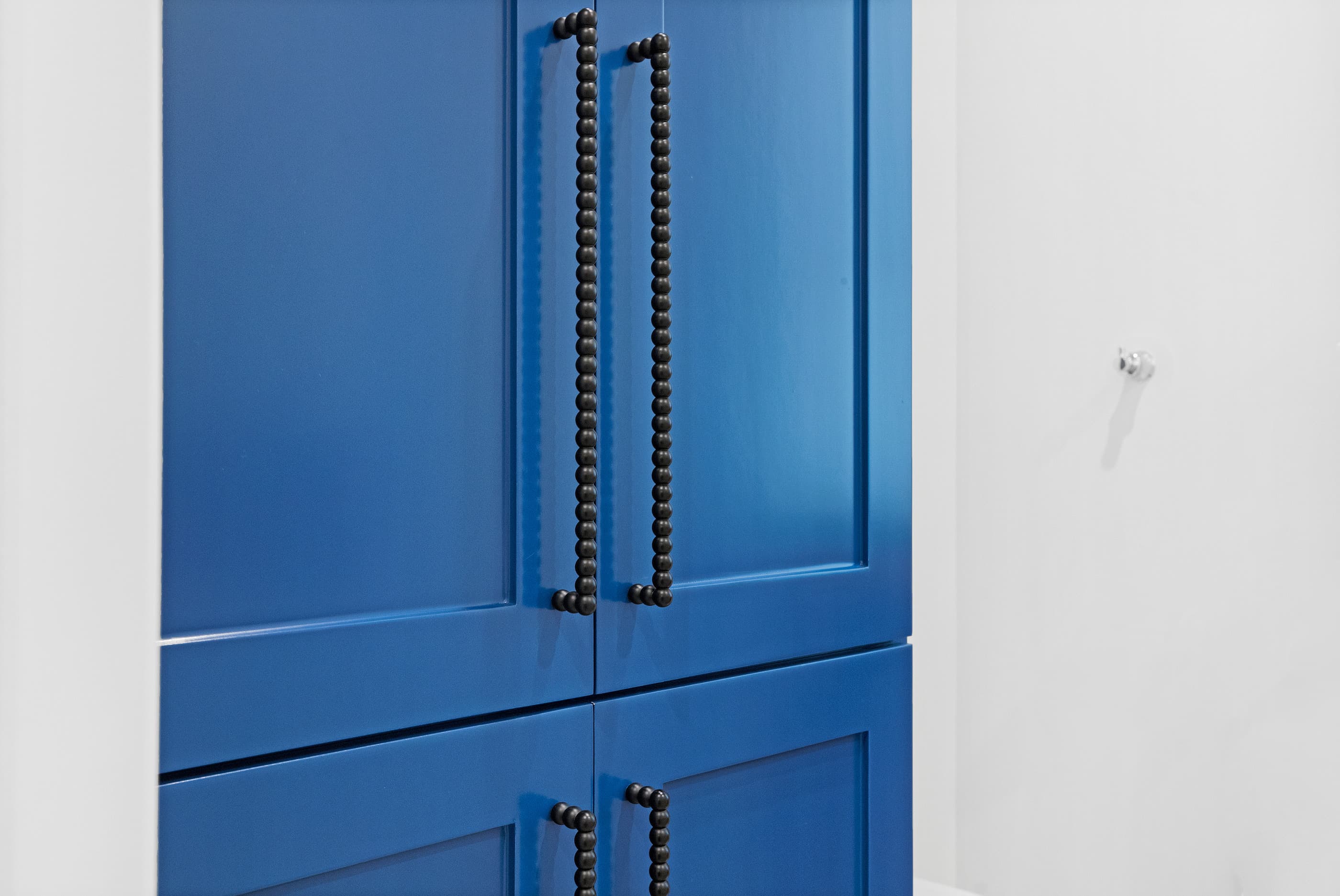 Blue painted built-in cabinet with black beaded pulls