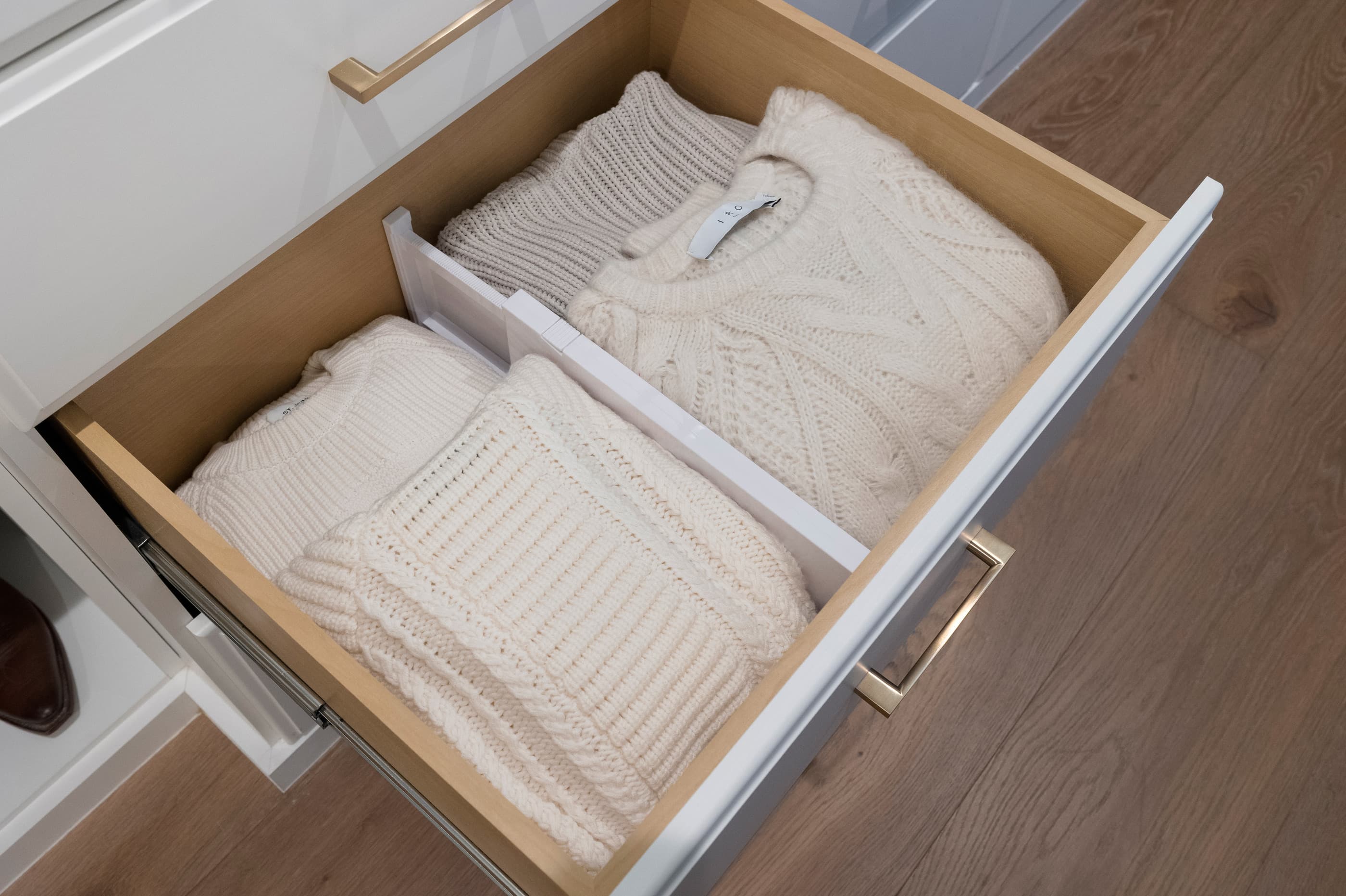 Wide dresser drawer with dividers neatly holding folded knit sweaters